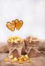 Paper bucket of caramel popcorn and peanuts. Two lollipop in the shape of a heart. Royalty Free Stock Photo