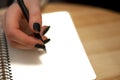 paper in business woman female hand writing notes on a table black manicure and blank letter Royalty Free Stock Photo