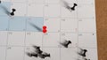 Paper calendar pinned on corkboard with thumbtacks highlighting specific dates for appointments Royalty Free Stock Photo