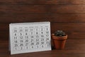 Paper calendar and succulent on table