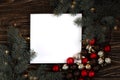 Paper card note with Christmas tree branches on the wooden backgraund. New Year concept