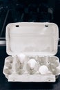 Paper cardboard box egg tray lies on table with demanding white eggs. Royalty Free Stock Photo