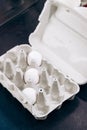 Paper cardboard box egg tray lies on table with demanding white eggs. Royalty Free Stock Photo