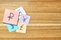 Paper cards with world currencies symbols on wooden table