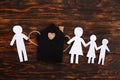 Paper chain cut family near toy house on wooden background. Divorce and broken family concept Royalty Free Stock Photo