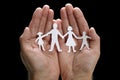 Paper chain family protected in cupped hands Royalty Free Stock Photo