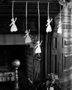 Paper Christmas decorations hang by ribbons in fireplace
