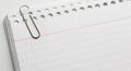 Paper clip fastening stack of lined notebook paper for writing Royalty Free Stock Photo