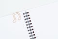Paper clip in shape of note on spiral notebook on white background Royalty Free Stock Photo