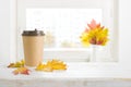 Paper coffee cup and autumn leaves on table with space Royalty Free Stock Photo