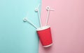 Paper coffee cup with cocktail straws on a colored pastel background, top view, minimalism. Royalty Free Stock Photo