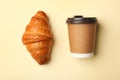 Paper coffee cup and croissant on color background. Mockup for design Royalty Free Stock Photo