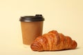 Paper coffee cup and croissant on color background Royalty Free Stock Photo