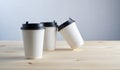 Paper coffee disposable cup for take away or to go, wooden table, space for design mock-up. Royalty Free Stock Photo