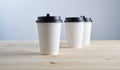 Paper coffee disposable cup for take away or to go, wooden table, space for design mock-up Royalty Free Stock Photo