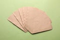 Paper coffee filters on pale olive background, flat lay