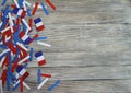 Paper confetti of the national colors of France, white-blue-red on a white wooden background with flags, concept Bastille day, Jul