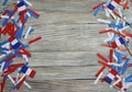 Paper confetti of the national colors of France, white-blue-red on a white wooden background with flags, concept Bastille day, Jul