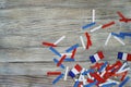 Paper confetti of the national colors of France, white-blue-red on a white wooden background with flags, concept Bastille day, Jul