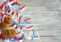 Paper confetti of national colors of France, white-blue-red on a white wooden background with flags and croissants, concept Bastil