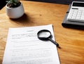 Paper contract on woode desk with magnifying glass Royalty Free Stock Photo