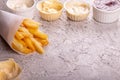 Paper conus of french fries chips potato and sauces on gry concrete background. copy space Royalty Free Stock Photo