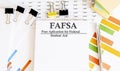 Paper with Corrective and Preventive FAFSA action plans on a table with charts