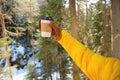 paper cup with a black lid in the hands of a woman in mittens