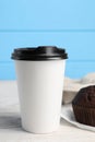 Paper cup with black lid on white wooden table. Coffee to go Royalty Free Stock Photo