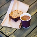 Paper cup of coffee with foam, piece of chocolate cake, lying on wooden table, top view. Vintage tone, coffee time. With Royalty Free Stock Photo