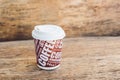A paper cup with coffee on an old wooden background Royalty Free Stock Photo