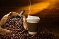 Paper cup of coffee with smoke and coffee beans Royalty Free Stock Photo