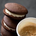 Paper cup coffee and stack of brown chocolate cookies with cream interlayer. Close-up shot. Soft focus Royalty Free Stock Photo