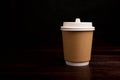 Paper cup for hot drinks isolated on dark background Royalty Free Stock Photo