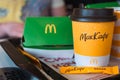 A paper cup of McDonald`s coffee with the inscription Maccafe in Russian and a hamburger in a box on a tray. Fast food restaurant