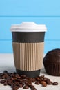 Paper cup with plastic lid and coffee beans on white table, closeup. Coffee to go Royalty Free Stock Photo