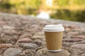 Paper cup on rocky ground outdoors, space for text. Coffee to go Royalty Free Stock Photo