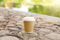 Paper cup on rocky ground outdoors, space for text. Coffee to go Royalty Free Stock Photo