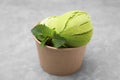 Paper cup with tasty matcha ice cream on grey table, closeup Royalty Free Stock Photo