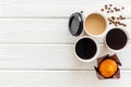 Paper cups with black coffee and cappuccino to take away, beans, muffin on white wooden background top view mockup Royalty Free Stock Photo