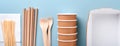 Paper cups, dishes, bag, wooden forks, drinking straws, fast food containers, wooden cutlery on light blue background. Eco craft p Royalty Free Stock Photo