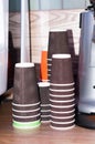 paper cups in stacks near coffee machine on wooden table in cafe Royalty Free Stock Photo