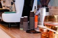 Paper cups in stacks on wooden counter near metal coffee machine Royalty Free Stock Photo