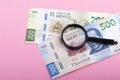 Paper currency of Mexico and magnifier on pink background, mexican pesos