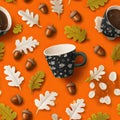 paper cut art style composition of coffee cup, leaves, and acorns on orange background, seamless pattern Royalty Free Stock Photo