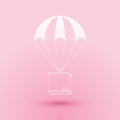 Paper cut Box flying on parachute icon isolated on pink background. Parcel with parachute for shipping. Delivery service