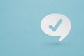 Paper cut Check mark in bubble speech icon isolated on grunge blue background. Choice button sign. Checkmark symbol. Speech bubble