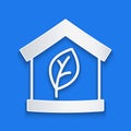 Paper cut Eco friendly house icon isolated on blue background. Eco house with leaf. Paper art style. Vector Royalty Free Stock Photo