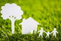 Paper cut of family with house and tree on grass Royalty Free Stock Photo