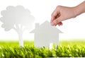 Paper cut of family house and tree on green grass Royalty Free Stock Photo